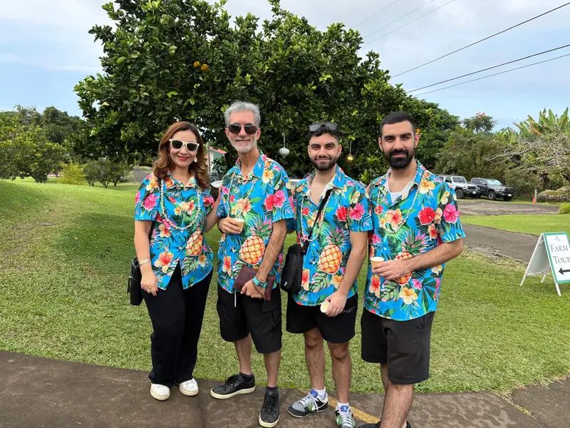 Arsi with his mom, dad and brother, standing outside in matching tropical shirts