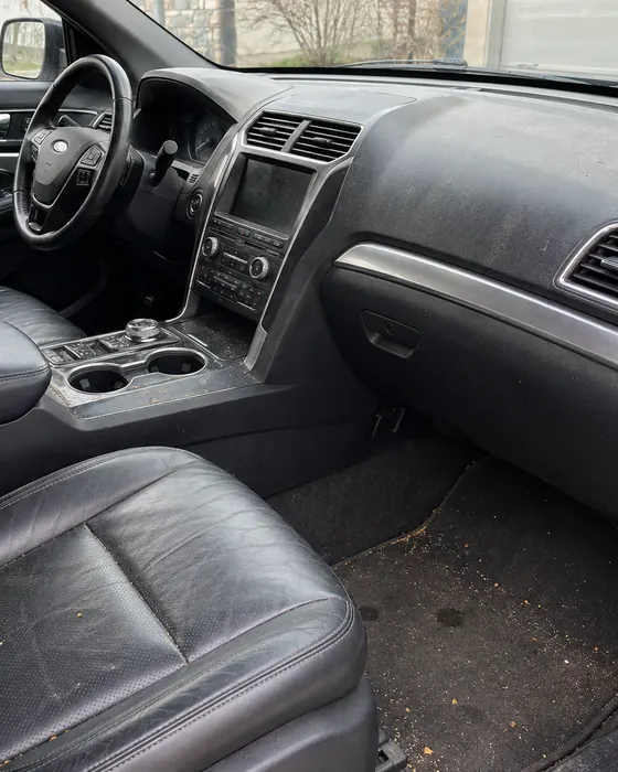 Front seat and floor mat of a family SUV with crumbs and dirt, before the Reset